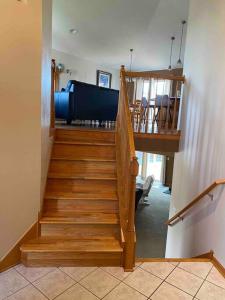 a wooden staircase with a piano in a room at Beautifully Furnished 5-Bedroom in Rochester
