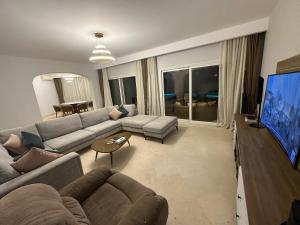 ein Wohnzimmer mit einem Sofa und einem Flachbild-TV in der Unterkunft GS 18 Villa in Hurghada