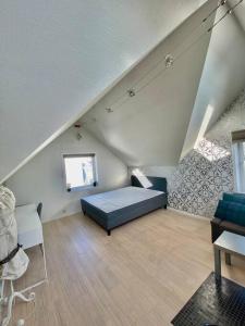 um quarto no sótão com uma cama e um sofá em Renewed Loft close to the city center em Stavanger