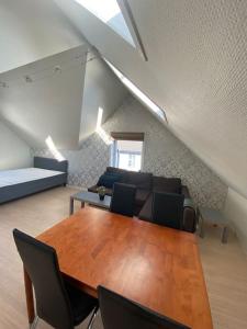 uma sala de estar com uma mesa de madeira e cadeiras em Renewed Loft close to the city center em Stavanger