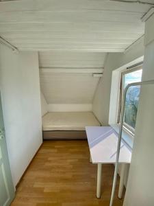 um pequeno quarto com uma cama e uma janela em Renewed Loft close to the city center em Stavanger