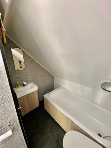 uma casa de banho com uma banheira, um WC e um lavatório. em Renewed Loft close to the city center em Stavanger