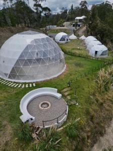 un gran edificio con cúpula en un campo con tiendas de campaña en NaturHotel, en Cuenca