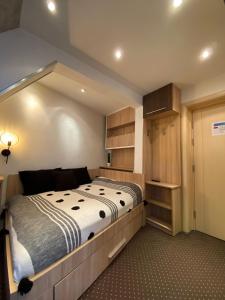 a bedroom with a large bed and some cabinets at Apartment Dunja Konaci in Kopaonik