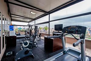 a gym with cardio equipment and a view of a city at Full Jazz by Slaviero Hotéis in Curitiba