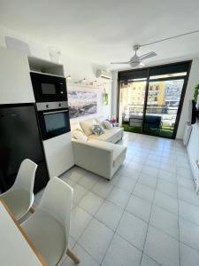 ein Wohnzimmer mit einem Sofa, einem Tisch und Stühlen in der Unterkunft Apartemento piscina centro calella 3 min playa in Calella