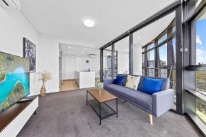 ein Wohnzimmer mit einem Sofa und einem Tisch in der Unterkunft Warm and cozy 3 Bed APT in Sydney