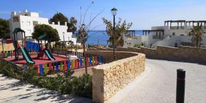 a playground on the side of a street next to the ocean at Sol y Mar, Cala Merced in El Campello