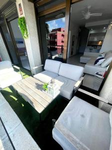 ein Wohnzimmer mit weißen Sofas und einem Tisch in der Unterkunft Apartemento piscina centro calella 3 min playa in Calella