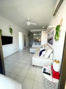 ein Wohnzimmer mit einem Sofa und einem TV in der Unterkunft Apartemento piscina centro calella 3 min playa in Calella