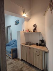 een keuken met een wastafel en een blauwe bank bij Apartament Karina in Baia Mare