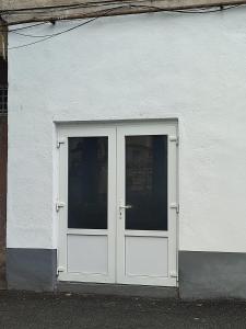 a white door on the side of a building at Apartament Karina in Baia Mare