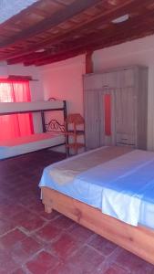 a bedroom with a bed and two chairs in it at Hostal 4 Manzanas in Santa Marta