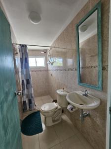 bagno con servizi igienici, lavandino e specchio di Apartahotel Santori Cartagena a Cartagena de Indias