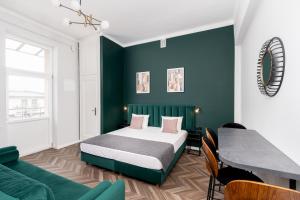 ein Schlafzimmer mit einem Bett und einer grünen Wand in der Unterkunft Wawel Boutique Residence - Krakow Old Town in Krakau