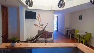 a hammock in a room with a table and chairs at Hostal 4 Manzanas in Santa Marta