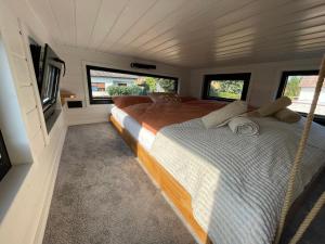 ein großes Bett in einem Zimmer mit Fenstern in der Unterkunft Tinyhaus Marie von Tinyhaus Steinhude in Steinhude