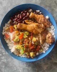 a blue bowl of food with rice and chicken and beans at Tayta Surf House in Lobitos