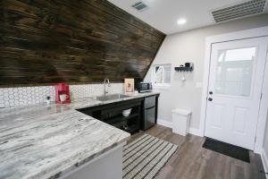 a kitchen with a sink and a wooden wall at The Maverick: A-Frame w/ Hammock and Tree Top View in New Braunfels