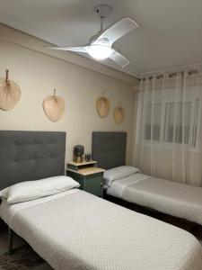een kamer met 3 bedden en een plafond bij Apartamento centrico Venecia in Sevilla