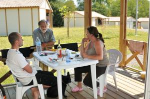 a group of people sitting around a table on a patio at La palombe in Orist