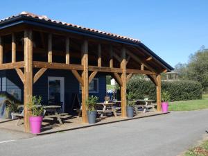a wooden pavilion with picnic tables and potted plants at La palombe in Orist