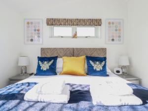利斯卡德的住宿－20 Meadow Retreat，一间卧室配有一张带蓝色和黄色枕头的大床