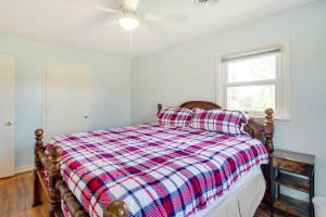 a bedroom with a bed with a plaid blanket and a window at Harrisonburg Family Home with Deck, 4 Mi to Downtown in Harrisonburg