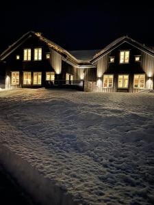 a large building in the snow at night at Fjellhytte på Hovden in Hovden