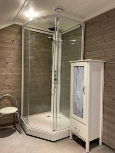 a glass shower in a room with a chair at Fjellhytte på Hovden in Hovden