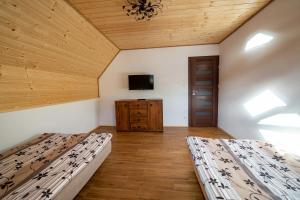two beds in a room with a tv on the wall at Nad Wilczym Potokiem in Baligród