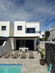 a white house with a patio and a swimming pool at Casa Oona in Playa Blanca