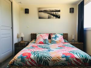a bedroom with a bed with a colorful blanket at Les Balusets in Vinezac