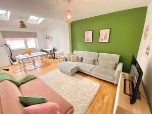 a living room with a couch and a green wall at Modern and Comfy 1-Bedroom Flat in Wembley in London
