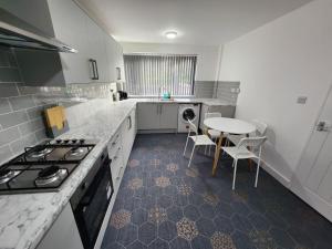 a kitchen with a table and a table and chairs at 4 Bedroom 2 Bathroom Shared House - Near BHX and NEC in Birmingham