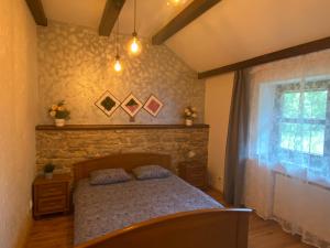 a bedroom with a bed and a stone wall at Homies Inn in Celiny