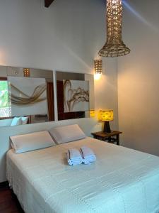 1 dormitorio con 1 cama con 2 toallas en Pousada Casa Mucugê, en Porto Seguro