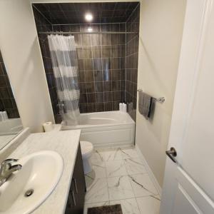 ein Bad mit einem Waschbecken, einem WC und einer Dusche in der Unterkunft New Niagara Retreat - Entire Home, 15 min drive to Falls, Sleeps 9, 4BDR in Thorold