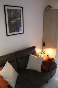 a brown couch with pillows in a living room at Happy Homes Melle Centre, Near Ghent! in Melle
