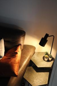 a lamp sitting on a table next to a couch at Happy Homes Melle Centre, Near Ghent! in Melle