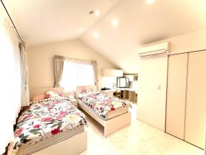 a bedroom with two beds and a window at Bell house in Tokyo