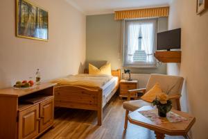 Landhotel Gasthof zur Post في وينتربرغ: غرفة نوم بسرير وكرسي وطاولة