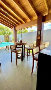 a living room with a table and chairs and a pool at Residencial Buritis-Tarumã Hípica Park in Bonito