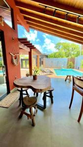 a room with a table and chairs and a pool at Residencial Buritis-Tarumã Hípica Park in Bonito