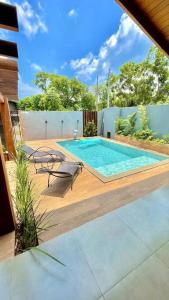 a swimming pool on a wooden deck with chairs at Residencial Buritis-Tarumã Hípica Park in Bonito