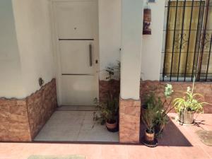 een voordeur van een gebouw met potplanten bij Casa Mis Viejos in Potrero de los Funes