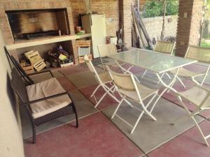 een glazen tafel en stoelen op een patio bij Casa Mis Viejos in Potrero de los Funes +9 foto's