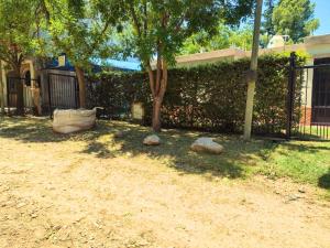 een hek met een boom en stenen in een tuin bij Casa Mis Viejos in Potrero de los Funes