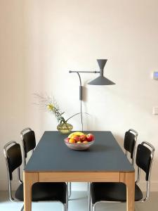a table with a bowl of fruit and a lamp at LE GARAGE Downtown serviced apartment in The Hague