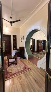 an archway in a living room with a table at Vijai Mahal - A Colonial Homestay in Ajmer